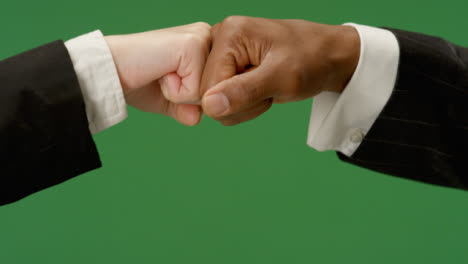 CU-Colleagues-in-suits-fist-bump-on-green-screen
