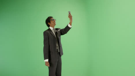 Annoyed-man-trying-find-phone-signal-on-green-screen