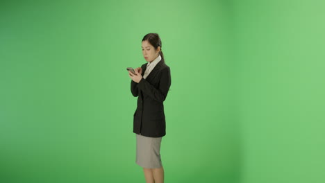 Businesswoman-texting-on-phone-with-green-screen
