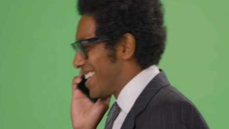 CU-Happy-Businessman-walking-and-talking-on-phone-with-green-screen
