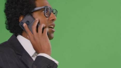 CU-Businessman-walking-and-talking-on-phone-with-green-screen