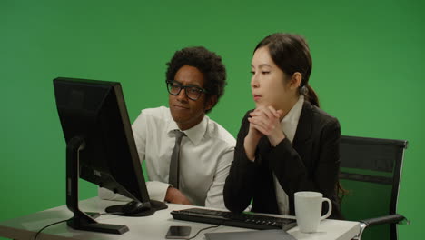 Two-Colleagues-Look-Worried-at-Computer-on-Green-Screen