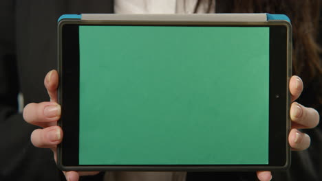 Woman-Holding-Tablet-with-Green-Screen-At-Camera