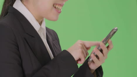 CU-Smiling-Businesswoman-using-phone-with-green-screen