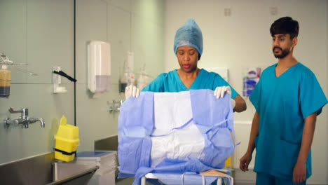 Medical-Staff-Unfolding-Surgical-Gown