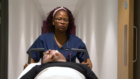 Female-médico-staff-wheeling-patient-in-hospital-bed