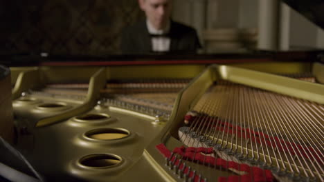 Dentro-de-un-piano-de-cola-mientras-toca-pianistas-masculinos