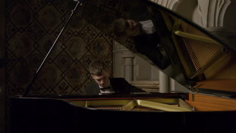 Pianista-masculino-tocando-un-piano-de-cola