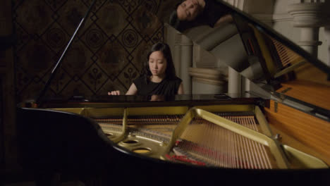 Pianista-femenina-tocando-un-piano-de-cola
