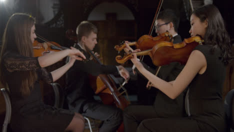 Side-View-Of-String-Quartet-Playing-During-Performance