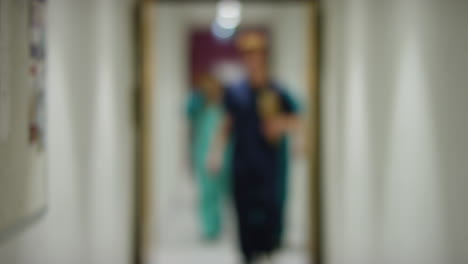 Blurred-Medical-Staff-Walking-Towards--In-Hospital-Corridor