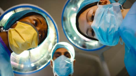 Der-Chirurg-Kommt-Mit-Dem-Personal,-Das-Auf-Den-Patienten-In-Der-Operation-Herabschaut