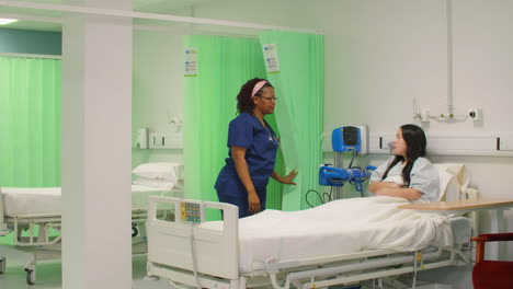 Female-Nurse-Opens-Curtain-Talking-to-Patient