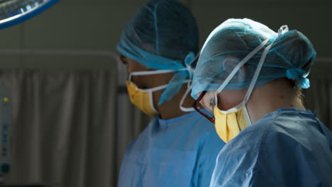 CU-Surgeon-Looks-Up-and-Passes-médico-Instrument