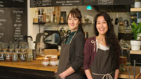 Retrato-de-dos-mujeres-baristas-en-un-café-sonriendo-a-la-cámara