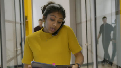 Woman-Talking-On-Smartphone-In-A-Corridor