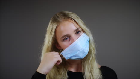 Young-Blonde-Woman-Removes-Face-Mask-Smiles