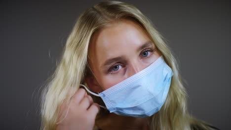 Smiling-Blonde-Woman-Removes-Face-Mask-Pan