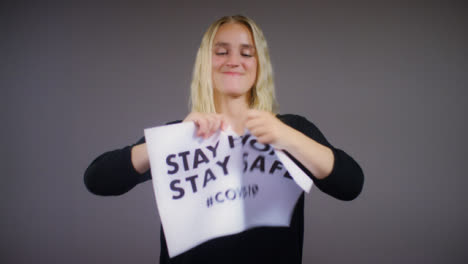 Young-Blonde-Woman-Rips-Stay-Home-Stay-Safe-Sign
