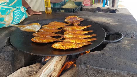 Spicy-fishes-being-fried-in-a-big-cast-iron-pan-in-a-road-side-eatery-Hogenakkal-Tamil-Nadu-India