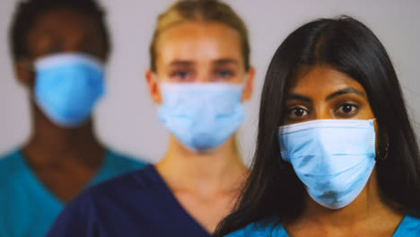 3-Young-Doctors-Wearing-Face-Masks-Pull-Focus