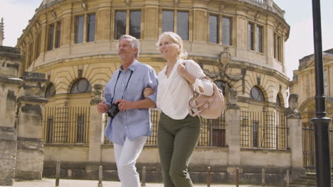 Low-Angle-Shot-of-Middle-Aged-Tourist-Couple-Walking-Around-City