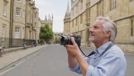 Tracking-Close-Up-of-Middle-Aged-Tourist-Taking-Photo-In-City