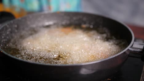 Slow-motion-closeup-of-cooking-oil-boiling-in-a-shallow-pan
