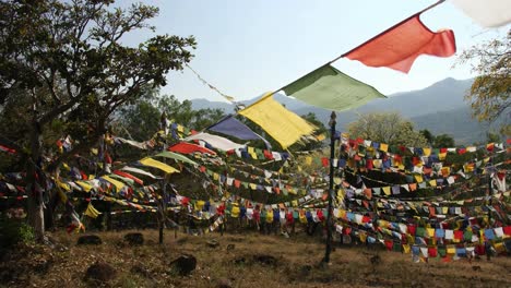 Beautiful-shot-of-colorful-Buddhist-flags-fluttering-in-the-wind-on-a-rope-during-a-bright-sunny-day