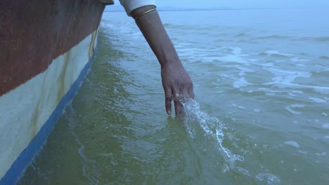 Close-up-of-a-girls-hand-feeling-the-water-from-a-boat-on-a-lake