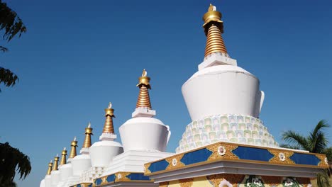 Kollegal-Karnataka--India--March-14-2020-Wide-angle-tilt-down-jib-shot-of-Buddhist-prayer-Stupas-at-the-Dhondenling-monastery-on-a-bright-sunny-day