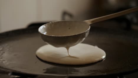 Closeup-slow-motion-view-of--steaming-hot-Dosa-on-a-cast-iron-pan.-Dosa-is-the-Indian-version-of-pancake-made-with-rice-flour-dough