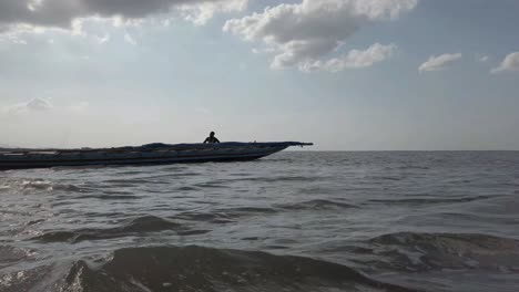 Insel-Irukkam-Andhra-Pradesh-Indien-20.-Juli-2019-Silhouette-Fischer,-Die-Ein-Holzboot-Auf-Einem-Flachen-See-Schieben?