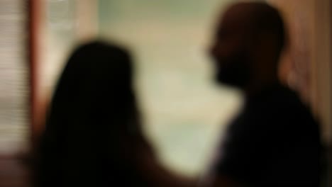 Medium-closeup-silhouetted-and-blurred-view-of-a-man-choking-a-woman