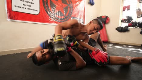 Bengaluru-Karnataka--India--February-13-2020-Two-adult-men-training-in-mixed-martial-arts-and-one-fighter-takes-down-the-other-to-the-ground