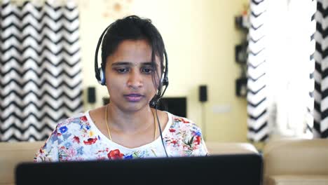 Closeup-of-an-Indian-business-woman-wearing-headphones-and-working-from-home-due-to-the-covid19-coronavirus-lockdown.