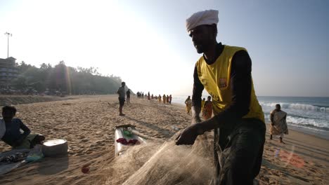 Varkala-Kerala--India--January-01-2020-Medium-shot-of-a-fisherman-preparing-his-fishing-net-during-a-bright-morning