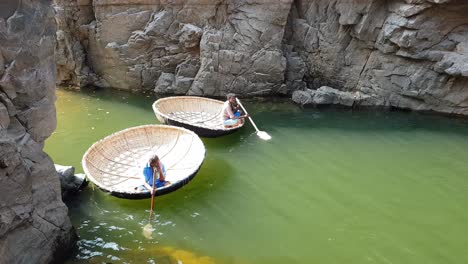 Hogenakkal-Tamilnadu-India--22-Dec-2018-Two-men-waiting-on-a-coracle-floating-on-water-in-river-Cauvery.