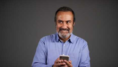 Middle-Aged-Man-Texting-and-Smiling-Portrait