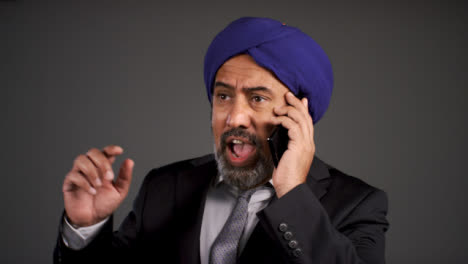 Frustrated-Middle-Aged-Negociosman-In-Turban-Shouting-On-Teléfono