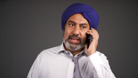 Smart-Annoyed-Middle-Aged-Man-In-Turban-Shouting-On-Phone