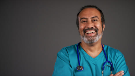 Middle-Aged-Friendly-Doctor-Smiling-and-Folding-Arms-Portrait