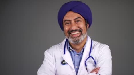 Pull-Focus-of-Middle-Aged-Doctor-In-Turban-Folds-Arms-and-Smiles