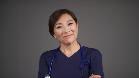 Pull-Focus-of-Middle-Aged-Doctor-Folding-Her-Arms-and-Smiling