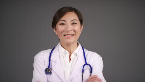 Pull-Focus-of-Middle-Aged-Doctor-Smiling-with-Folded-Arms