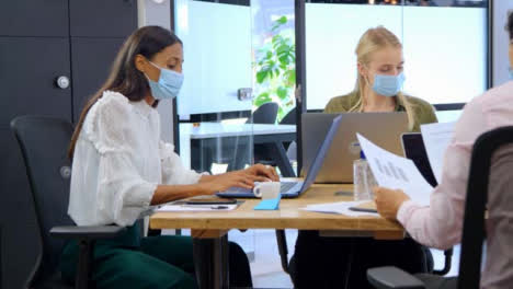 Three-Young-Business-Colleagues-In-Face-Masks-Working-In-Modern-Office