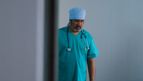 Concerned-Middle-Aged-Surgeon-Having-Conversation-On-Mobile-Phone