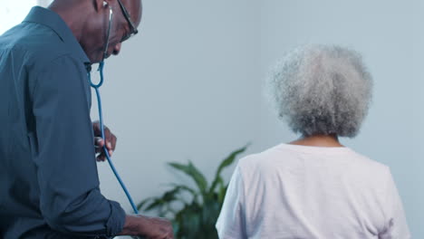 Middle-Aged-Male-Doctor-Uses-Stethoscope-On-Patient's-Back