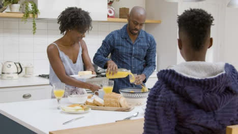 Kleiner-Junge-Schließt-Sich-Seiner-Familie-Während-Des-Frühstücks-Auf-Der-Kücheninsel-An-02