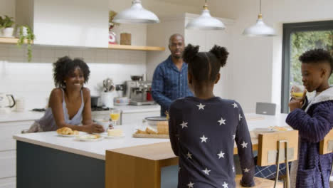 Young-Girl-Joins-Her-Family-at-Kitchen-Island-During-Breakfast